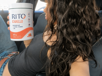 Mujer de cabello largo sosteniendo el pote de RITO Cabello en un auto